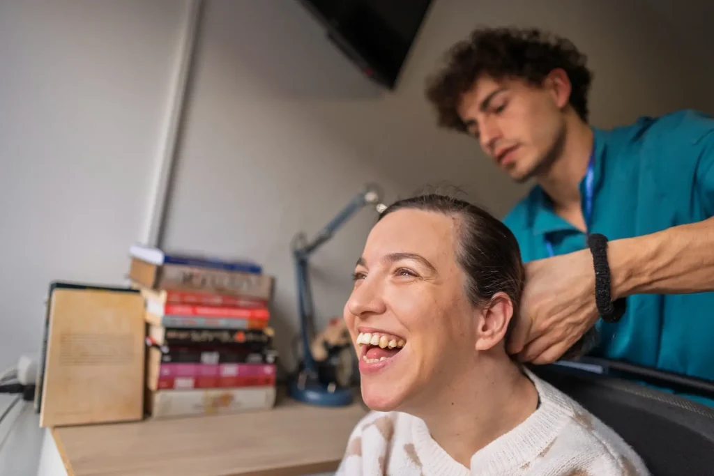 Support worker assisting a smiling woman at her desk