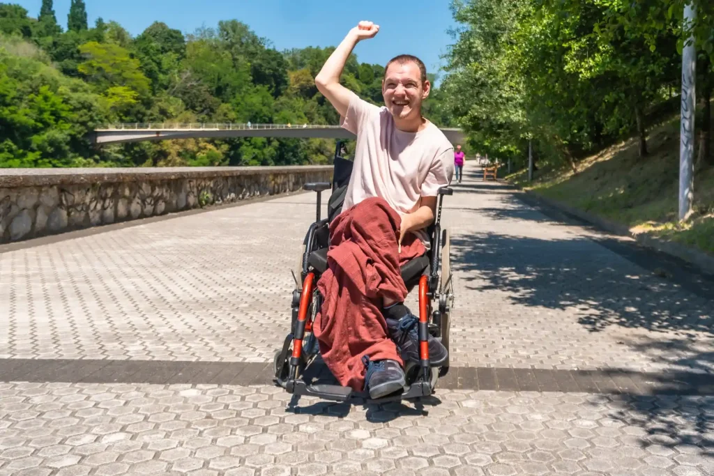 Smiling young man in a wheelchair outdoors